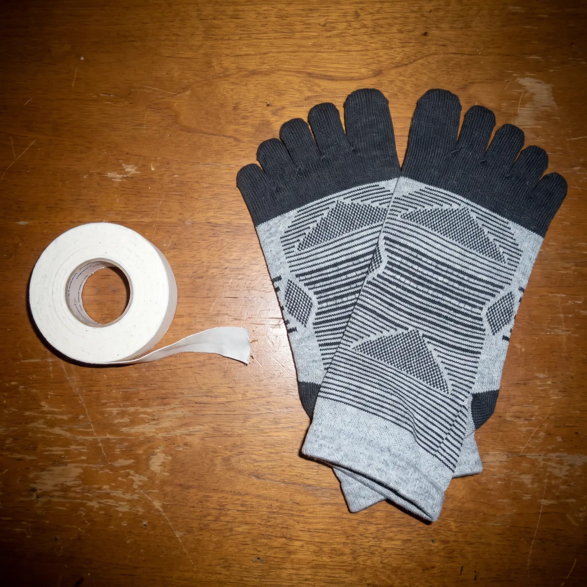 Athletic tape arranged beside Kintoe toe socks and hiking gear